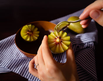 High angle view of woman holding fruit on table