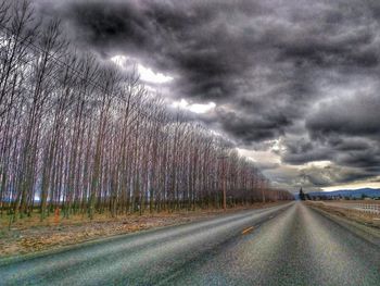 Country road against cloudy sky