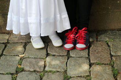 Low section of woman standing on cobblestone street