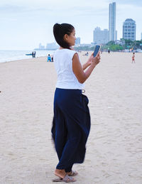 Side view of woman standing at beach