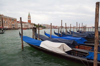 Gondola moored in grand canal against buildings and sky