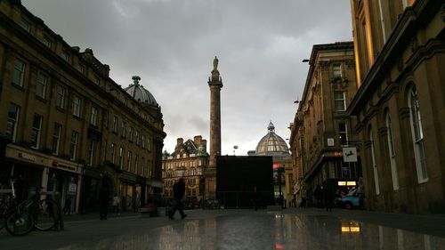 Buildings in city against cloudy sky