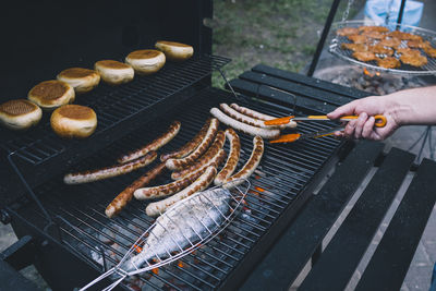 Close-up of fish and sausages on barbecue grill