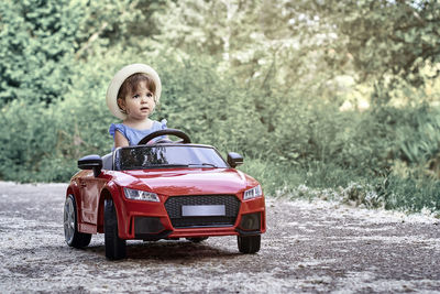 A girl riding a toy car