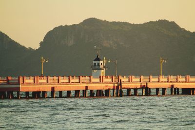 Pier over sea against sky during sunset