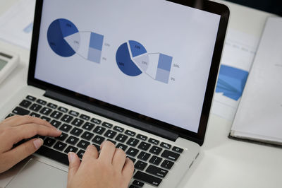 Low section of person using laptop on table