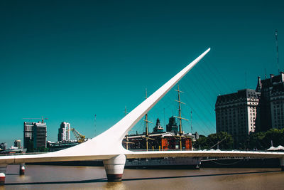 Bridge over buildings in city against clear sky