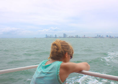 Rear view of woman looking at sea against sky