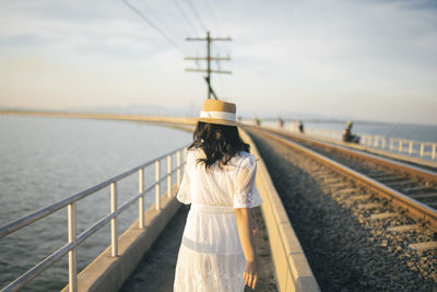 Rear view of woman walking on railway bridge