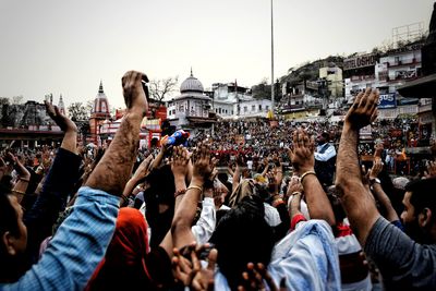 Crowd at city against clear sky