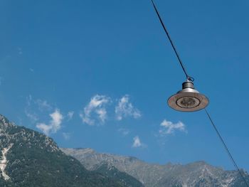 Low angle view of overhead cable car against blue sky