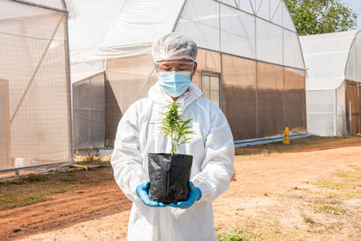 Man holding plant while standing outdoors