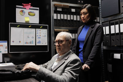 Rear view of businessman using digital tablet in office