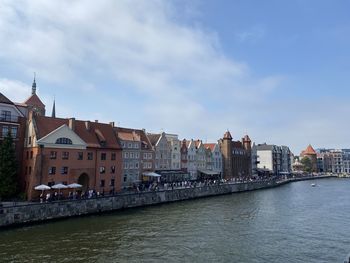 Buildings in city against cloudy sky