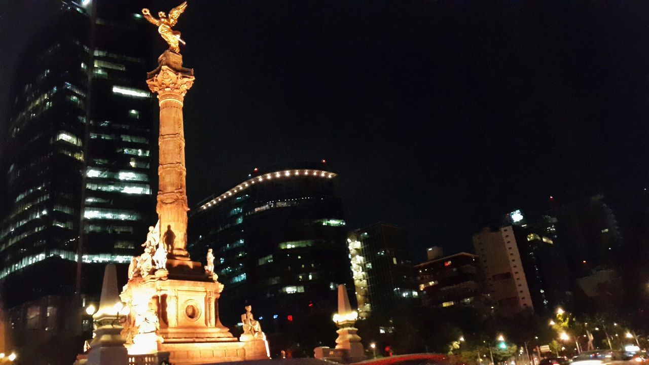 LOW ANGLE VIEW OF ILLUMINATED BUILDING AT NIGHT