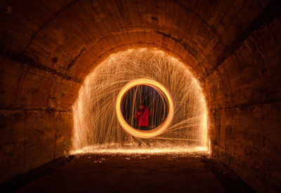 Man making wire wool in tunnel at night