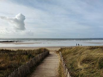 Footpath by sea against sky