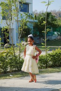 Portrait of cute girl standing against plants