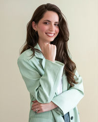 Portrait of young woman standing against white background