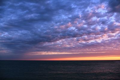 Scenic view of sea against dramatic sky during sunset