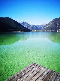 Scenic view of lake against clear blue sky