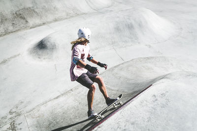 Sportsman skating at skateboard park during sunny day