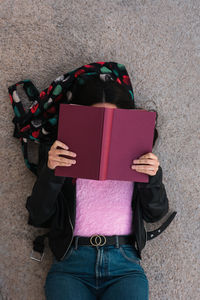 University student reads lying down on the floor