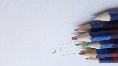 High angle view of multi colored pencils against white background