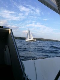 Sailboat sailing on sea against sky