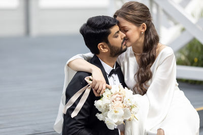 Side view of woman holding bouquet