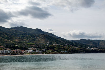 Scenic view of sea and mountains against sky