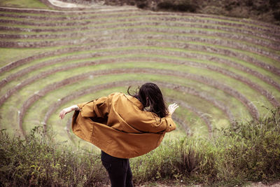 Dancer spins in centre of circle of stones- ancient inca ruins