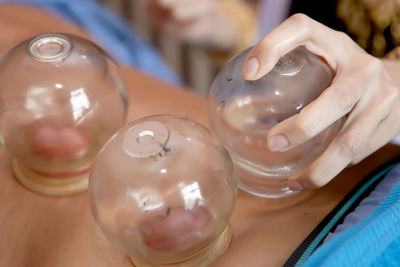 Close-up of hand holding glass on table