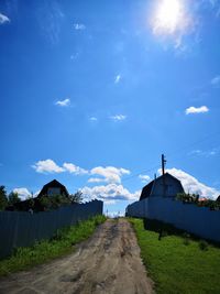 Road amidst plants against blue sky