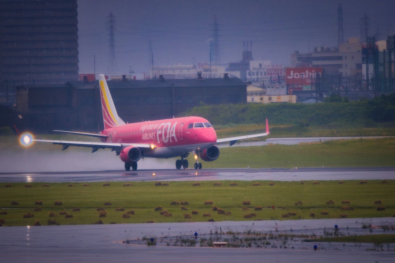 AIRPLANE FLYING OVER AIRPORT