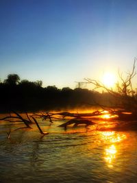 Scenic view of lake against clear sky during sunset