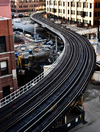 High angle view of railway bridge amidst buildings in city