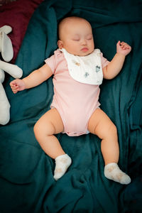 Portrait of cute baby boy lying on bed at home