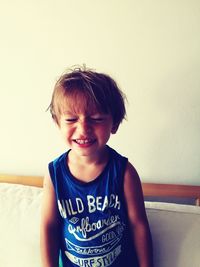 Portrait of smiling boy against wall at home