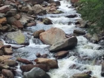 Close-up of water flowing through rocks in river