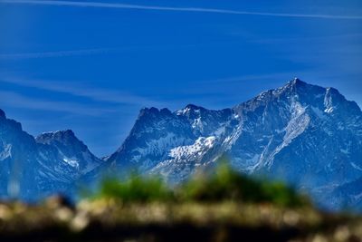 Scenic view of snowcapped mountains against blue sky