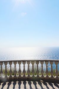 Railing by sea against sky