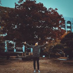 Man standing by built structure against trees