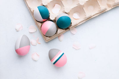 High angle view of multi colored eggs on white background