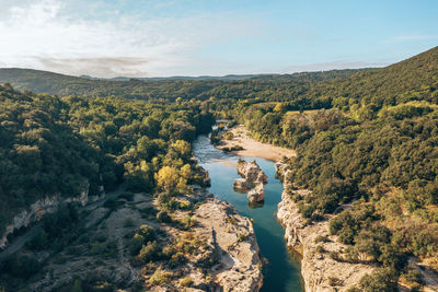 High angle view of river amidst trees against sky