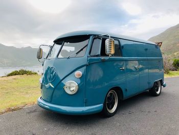 Vintage car on road by mountain against sky