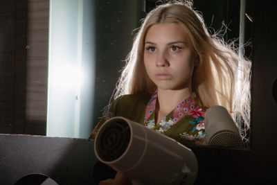 Portrait of teenage girl holding camera