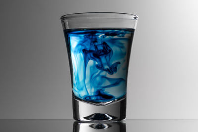 Close-up of glass against blue background