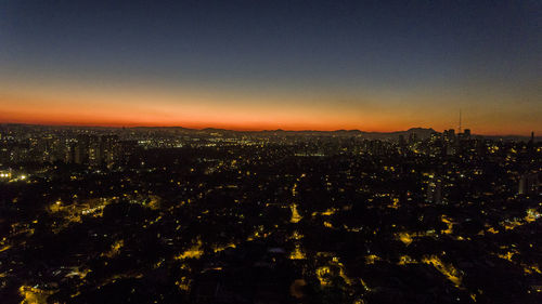 Illuminated cityscape against sky at night