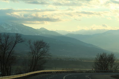 Road by mountains against sky